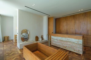 A modern bathroom with a wooden vanity, a large mirror, and a built-in bathtub. - Babylon (Cemagi)