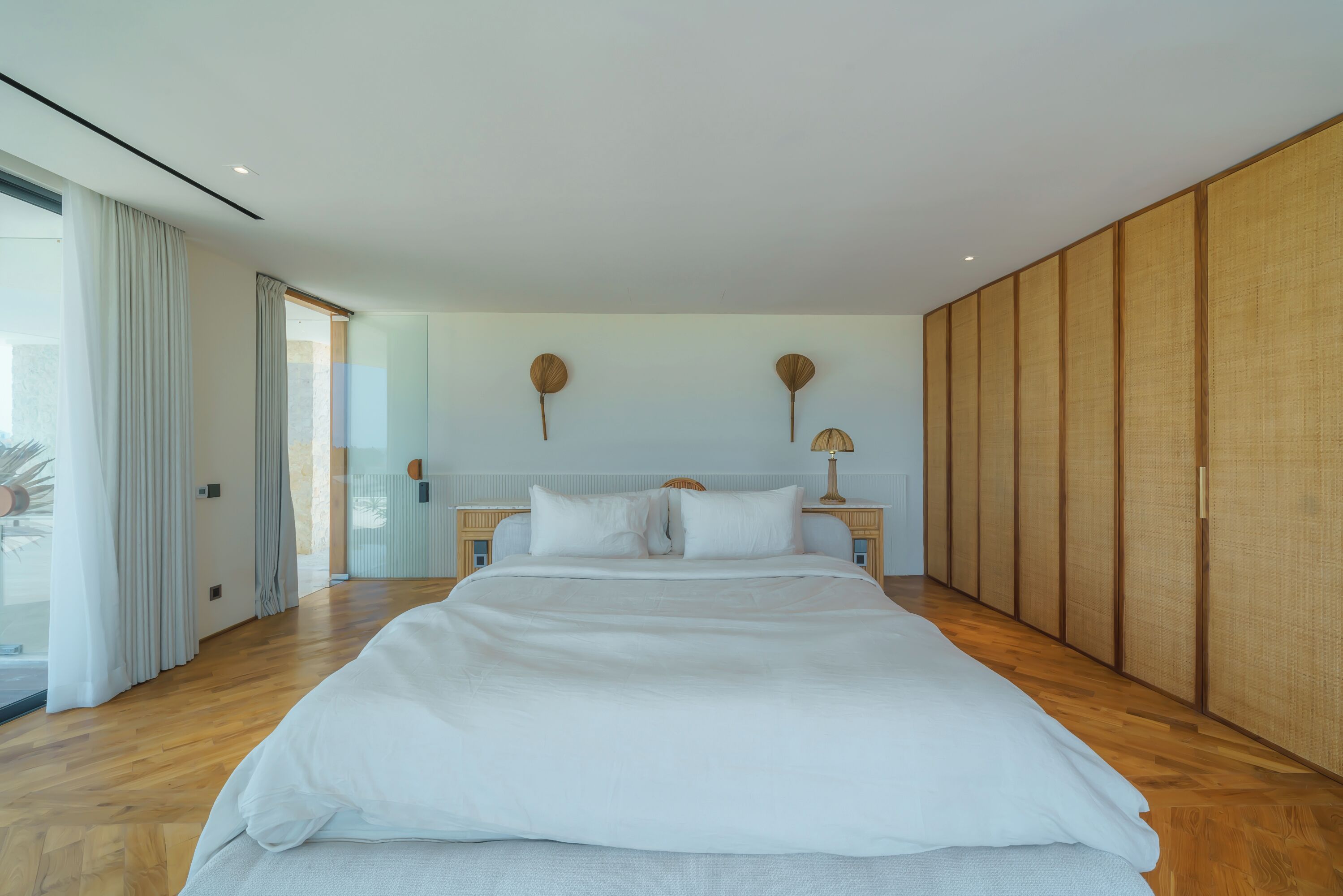 Una camera da letto moderna con un letto grande, un'armadio in legno e vista sull'esterno.
