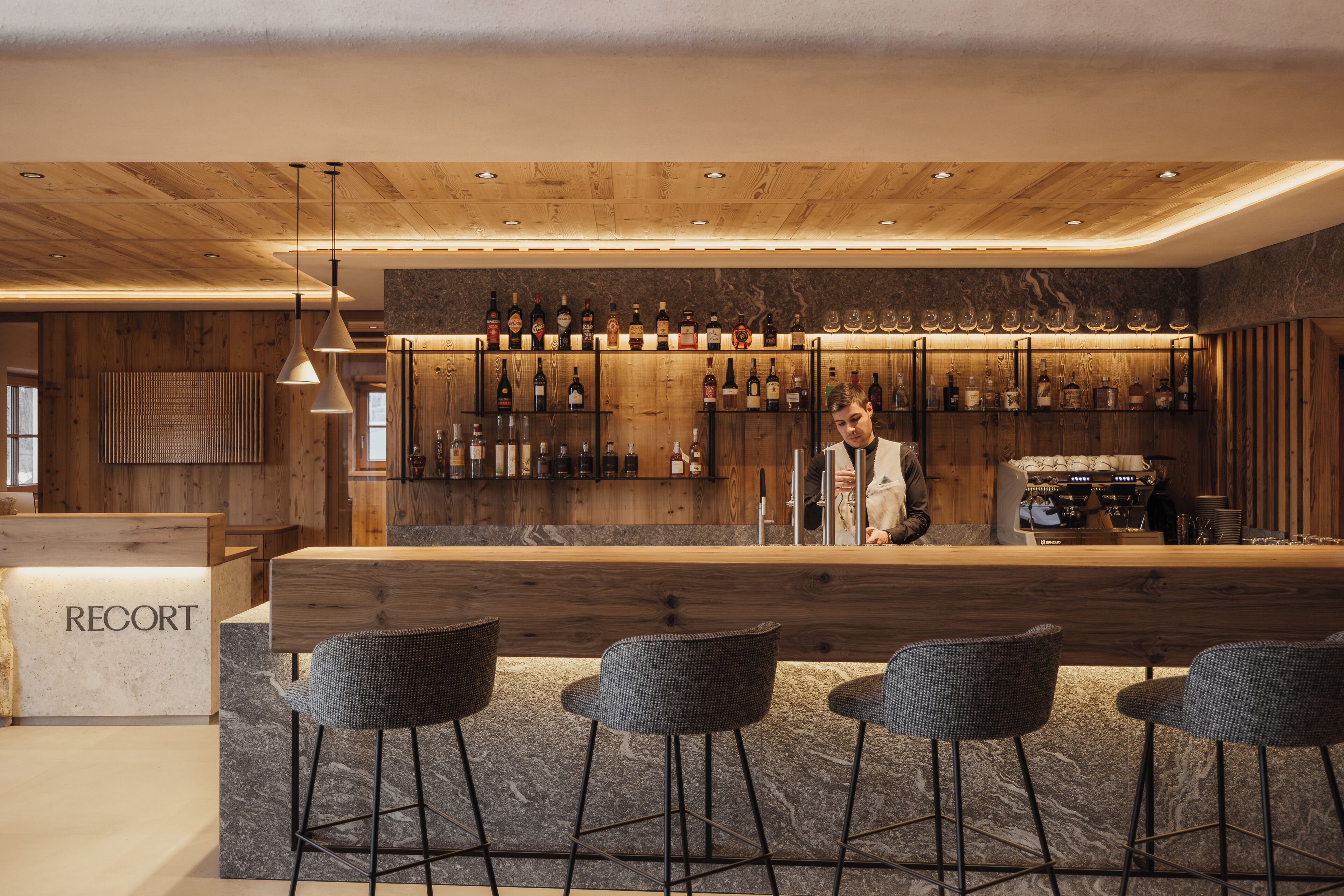 A bar area with wooden accents, a bar counter, and multiple seating options.