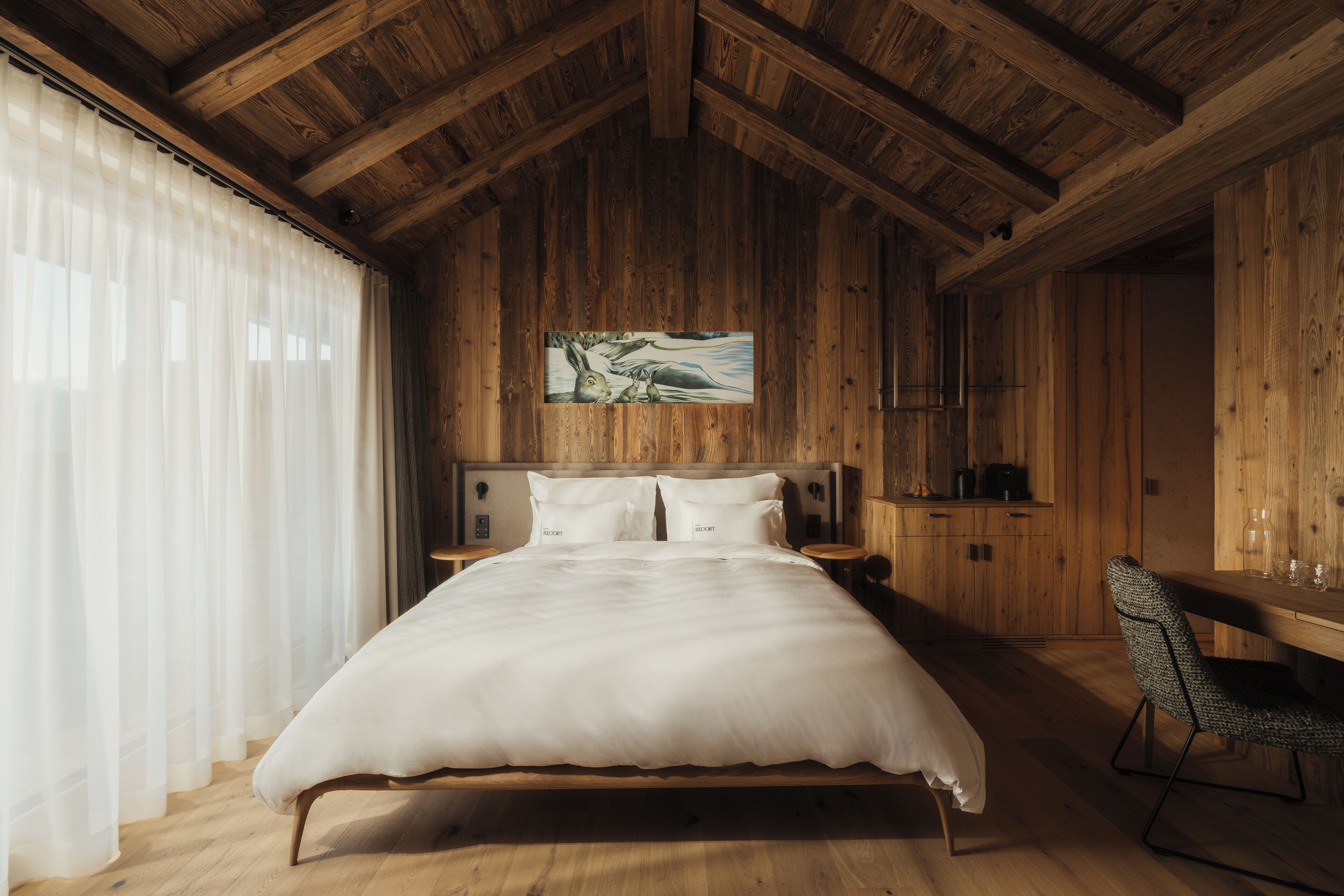 Ein Schlafzimmer aus Holz mit einem Bett, einem Schreibtisch und einem Stuhl.
