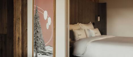 Un dormitorio con cama, almohadas y una obra de arte enmarcada en la pared.