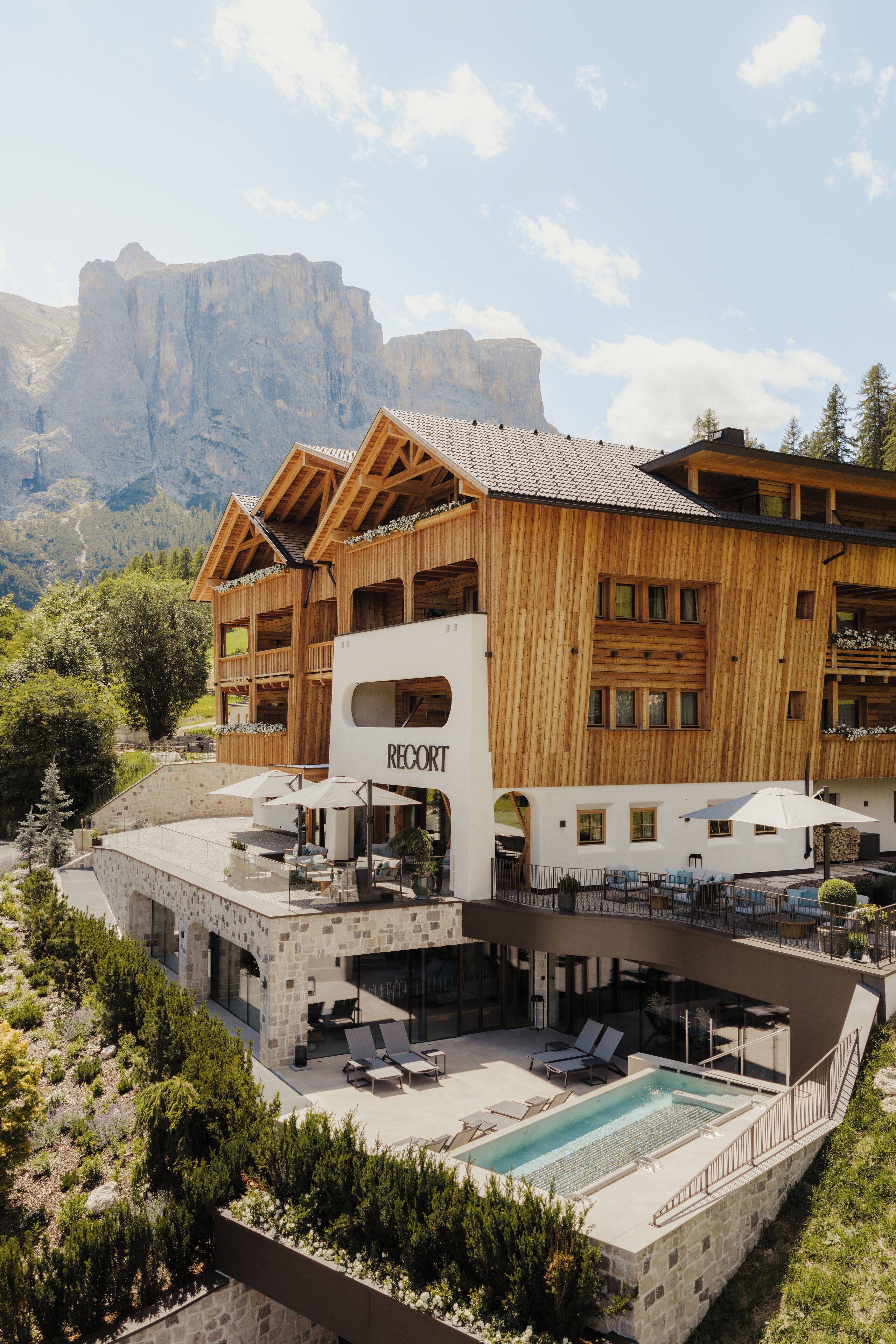 Un complexe hôtelier doté d’une piscine, d’un espace extérieur aménagé et offrant une vue sur les montagnes.