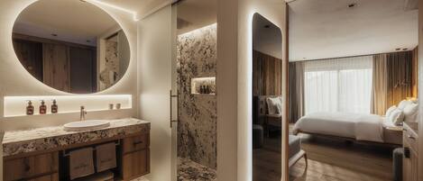 A modern bathroom with a marble sink, wooden cabinets, and a large mirror.