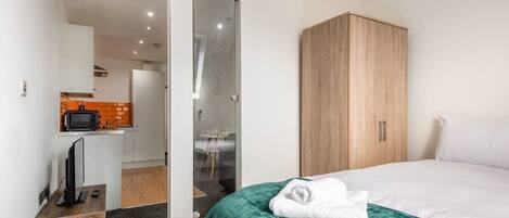 1 habitación, tabla de planchar con plancha y ropa de cama