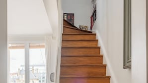 A wooden staircase with a chair and a bench in the foreground.