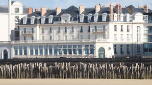 A row of white, multi-story buildings with uniform architectural style, featuring balconies and large windows. - L'Émeraude Malouine (Saint-Malo)