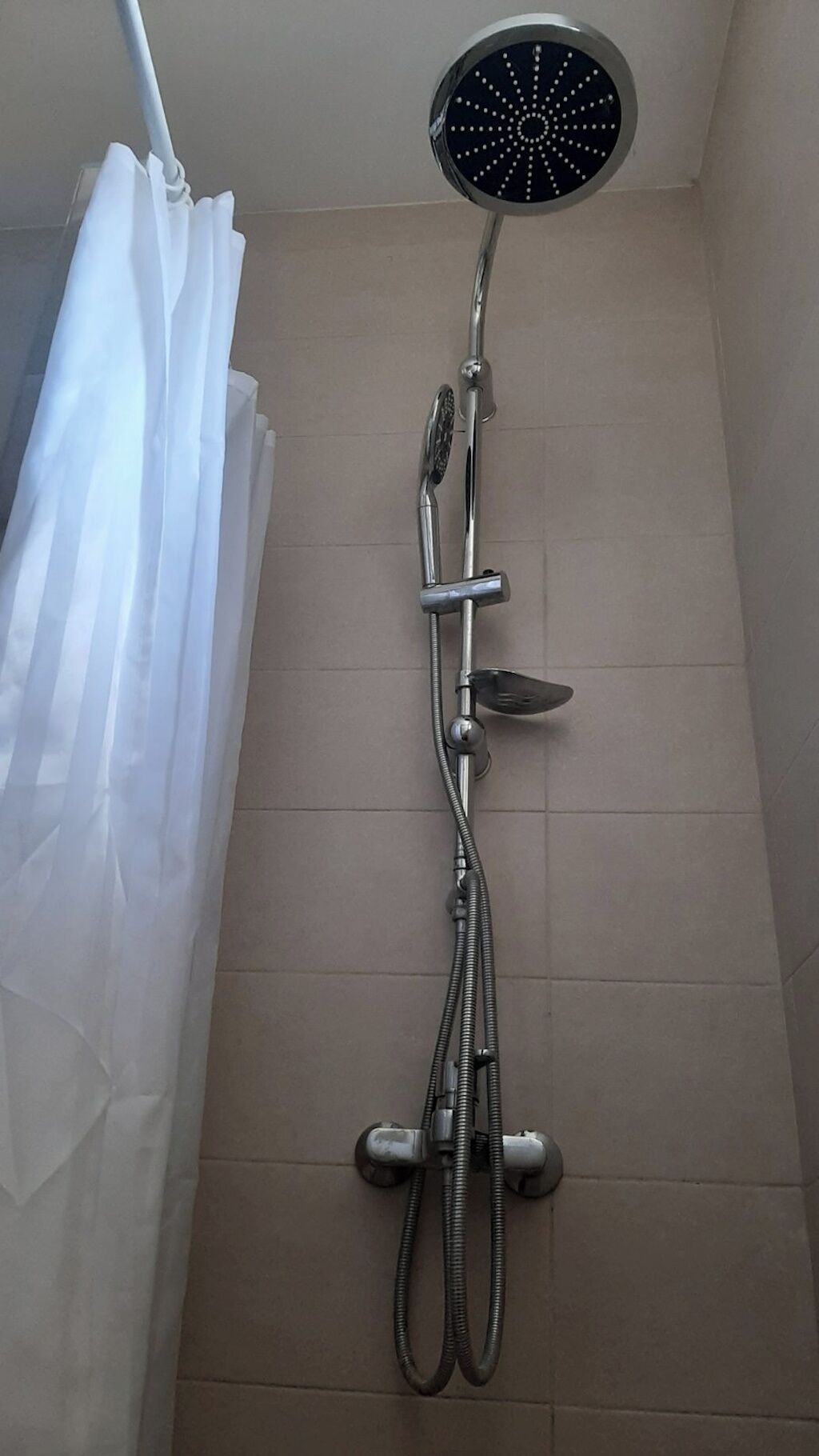 A shower with a handheld showerhead and a fixed rain showerhead.