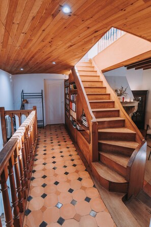 Een houten trap met betegelde vloer die uitkomt op een vloerplateau.