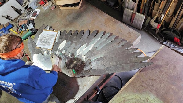 A workshop with tools and metal parts on a workbench.
