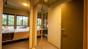 A bedroom with a bed, a window, a door, and a ceiling fan.