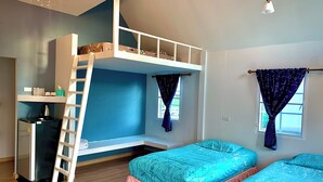 Une chambre de dortoir avec des lits superposés, un bureau et une échelle.