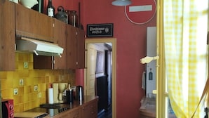 A kitchen with wooden cabinets, a green table, and a checkered floor. - A journey through time in the heart of the city (Chalon-sur-Saône)