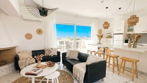 A modern living room with a black sofa, white coffee table, and a view of the outdoors. - Lilu Villa 2 With Private Pool and Seaview (Kos)