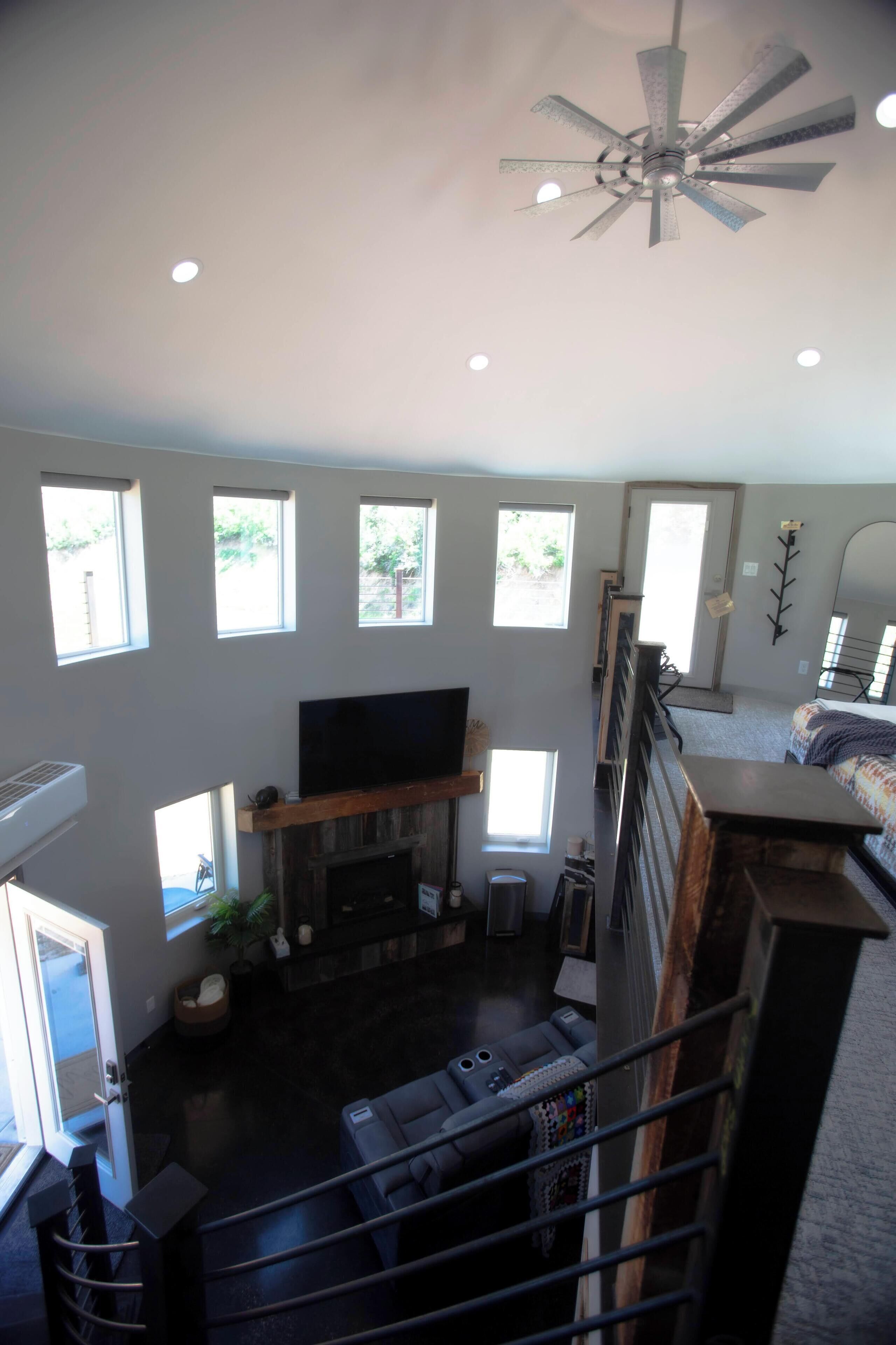 A spacious living area with a fireplace, a television, and a staircase leading to an upper level.
