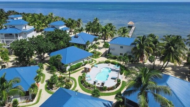 A resort with multiple buildings, a swimming pool, and a view of the ocean. - Seashell Suite, Garden & Pool Views @SapphireBeach (San Pedro Town)