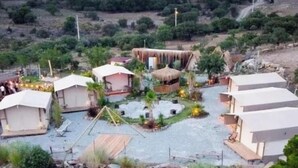 Ein Campingplatz mit mehreren Zelten und einer zentralen Struktur mit Strohdach.