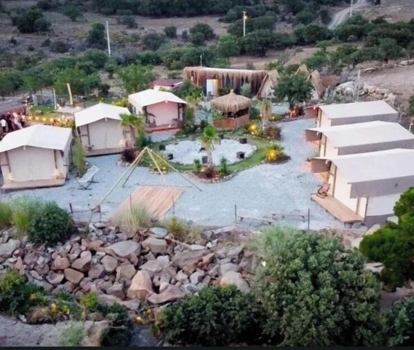 A campsite with several tents and a central thatched structure. - Masalevi Gümüşlük (Bodrum)