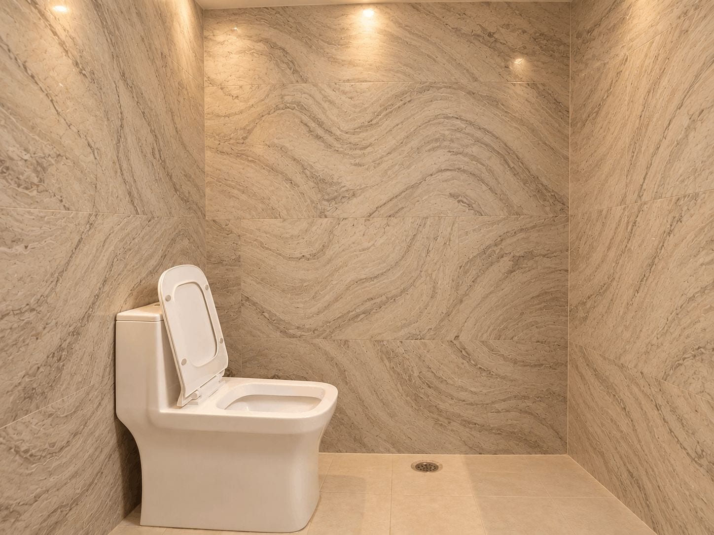 Un baño moderno con pared de mármol, inodoro blanco y zona de ducha.