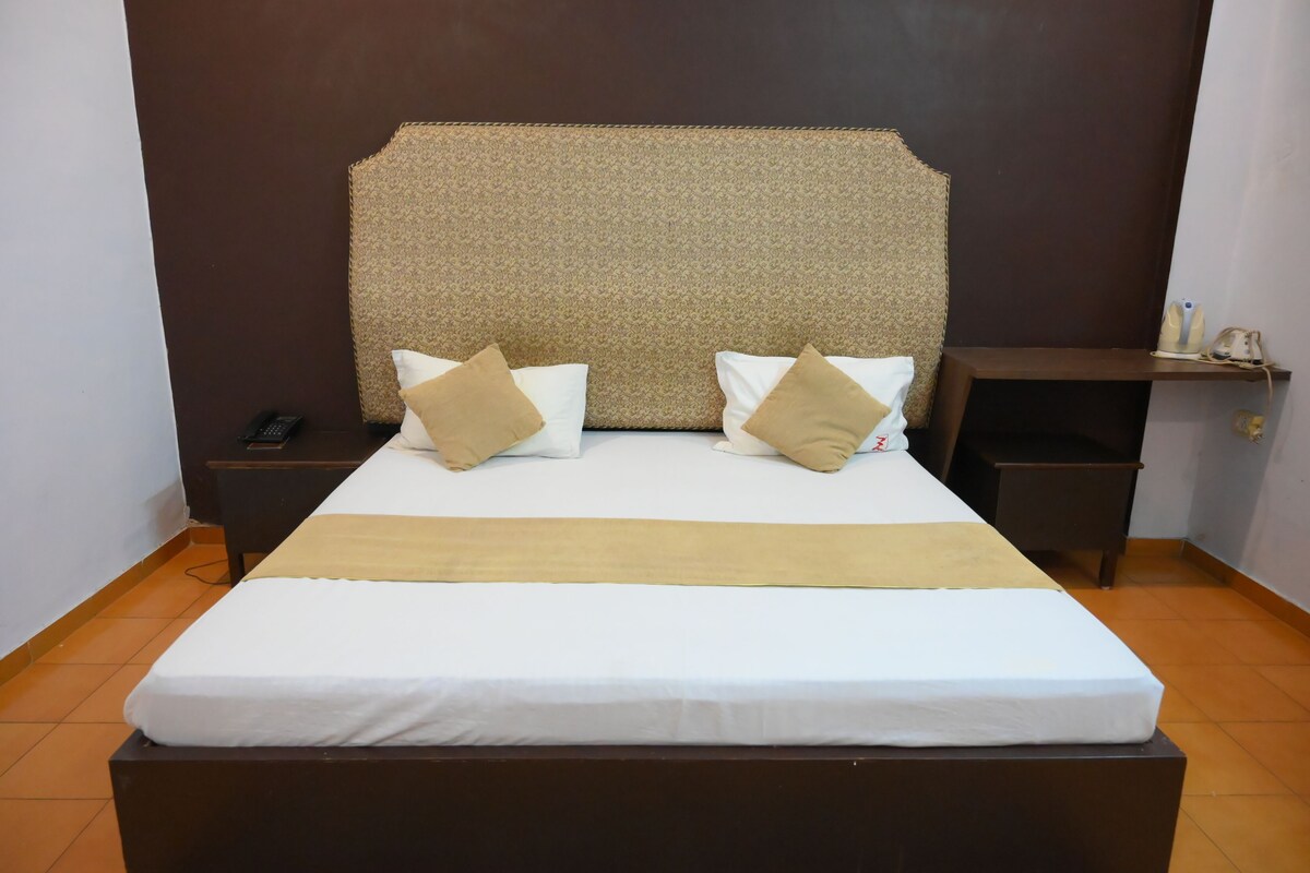 A bed with a headboard, two bedside tables, and a nightstand.