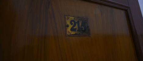 Una puerta de madera con una placa que muestra el número 215.