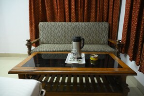 Una habitación con un sofá, una mesa de centro y una silla.