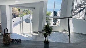 A spacious room with large windows, a staircase, and a potted plant. - Paradise House in Frigiliana (Frigiliana)