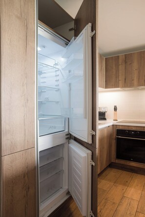 Una cocina moderna con refrigerador integrado, armarios de madera y lavavajillas.