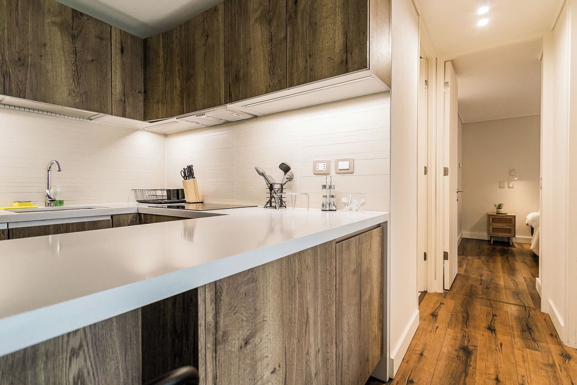 Una cocina moderna con una isla grande, electrodomésticos de acero inoxidable y armarios de madera.