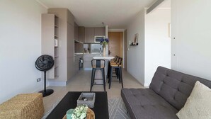 Un salon moderne avec un canapé, une table basse et un ventilateur.