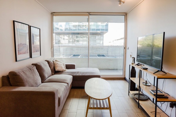 Relax in this cozy living room with a spacious sofa and enjoy the natural light from the balcony.