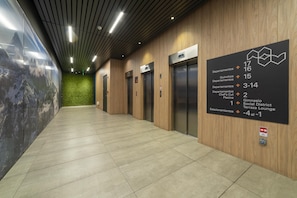 A hallway with elevators and a directional sign. - Stylish Urban Studio | Providencia Central View (Providencia)