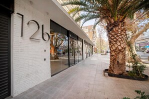 A building with large windows and a palm tree in front.