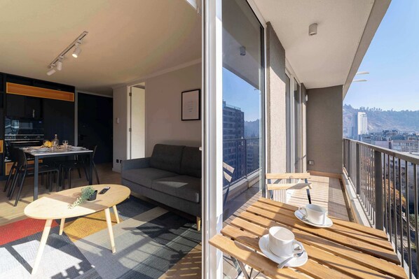 Un apartamento moderno con balcón, comedor y sala de estar.