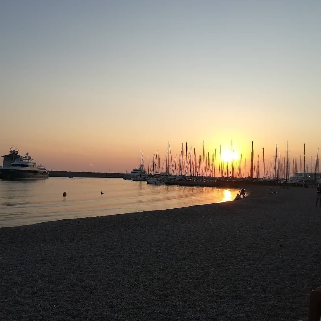 Een jachthaven met boten die aanmeren bij zonsondergang.