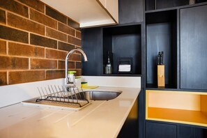 Een moderne keuken met een roestvrijstalen spoelbak, een kraan en een afwassigheid.