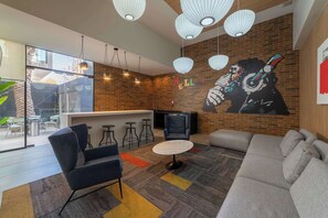 Un intérieur moderne comprenant un bar, des espaces pour s’asseoir et une fresque murale.