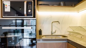 A modern kitchen with a built-in microwave, oven, and stainless steel sink. - Chic Las Condes Apt: 2BR, 2BA, Pool & Gym (Santiago)