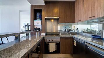 Una cocina moderna con encimeras de granito, electrodomésticos de acero inoxidable y armarios de madera.