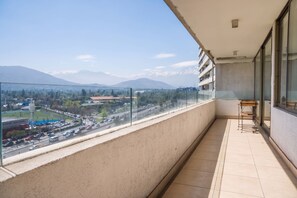 A balcony with a view of a cityscape and mountains.