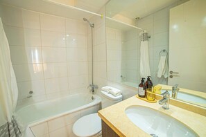 Een badkamer met een bad, toilet, wastafel en een spiegel.