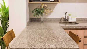 A kitchen with granite countertops, a microwave, a sink, and wooden cabinets. - Escape to the Heart of the City with Great Views (Santiago)