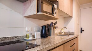 A kitchen with a built-in oven, a coffee maker, and a knife block on the countertop. - Downtown Stgo Studio: Balcony, WiFi & City Views! (Santiago)