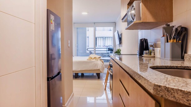 Une cuisine moderne équipée d’un réfrigérateur, d’une cuisinière et d’un plan de travail.