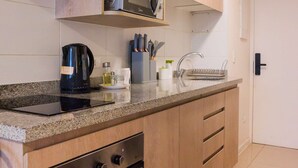 Une cuisine équipée de meubles en bois, d’un four à micro-ondes, d’une cuisinière, d’un évier et d’une machine à café.