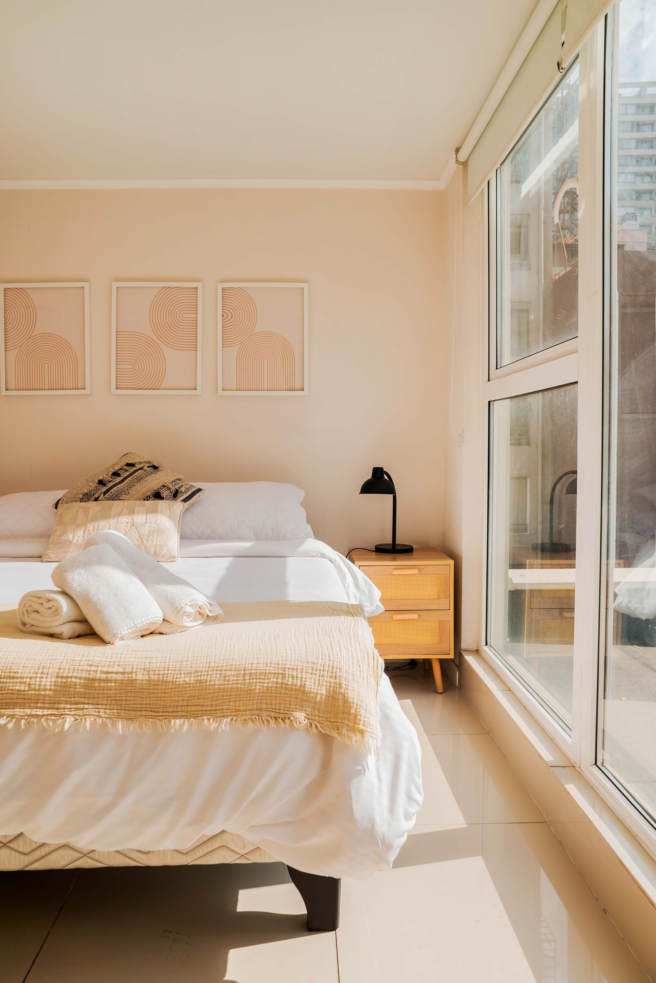 Ein Schlafzimmer mit einem Bett, einem Nachttisch und einem Fenster.