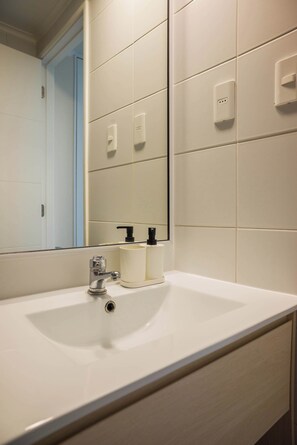 Ein Badezimmer mit Waschbecken, Spiegel und Toilette.