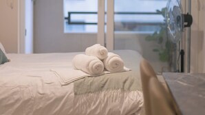 Una habitación de hotel con una cama, un ventilador y vistas a un balcón.