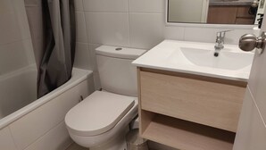 Une salle de bain moderne équipée de toilettes, d’un lavabo et d’une douche.