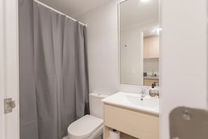Een badkamer met toilet, wastafel en douchegordijn.