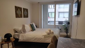 Une chambre d’hôtel équipée d’un lit, d’un bureau, d’une chaise, d’une fenêtre avec vue et d’un téléviseur à écran plat.